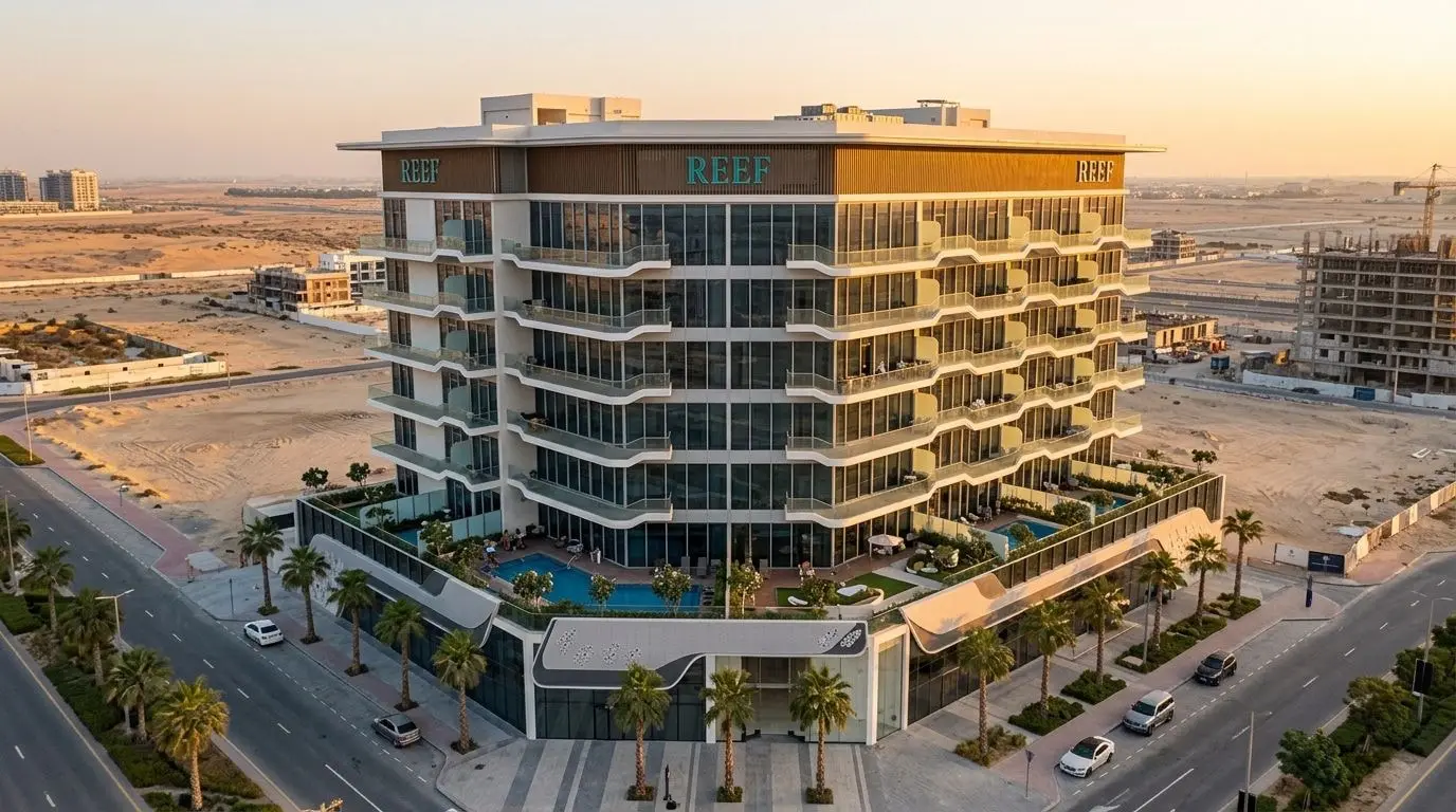 Nowoczesna wieża mieszkalna REEF 1000 w Dubailand o zachodzie słońca