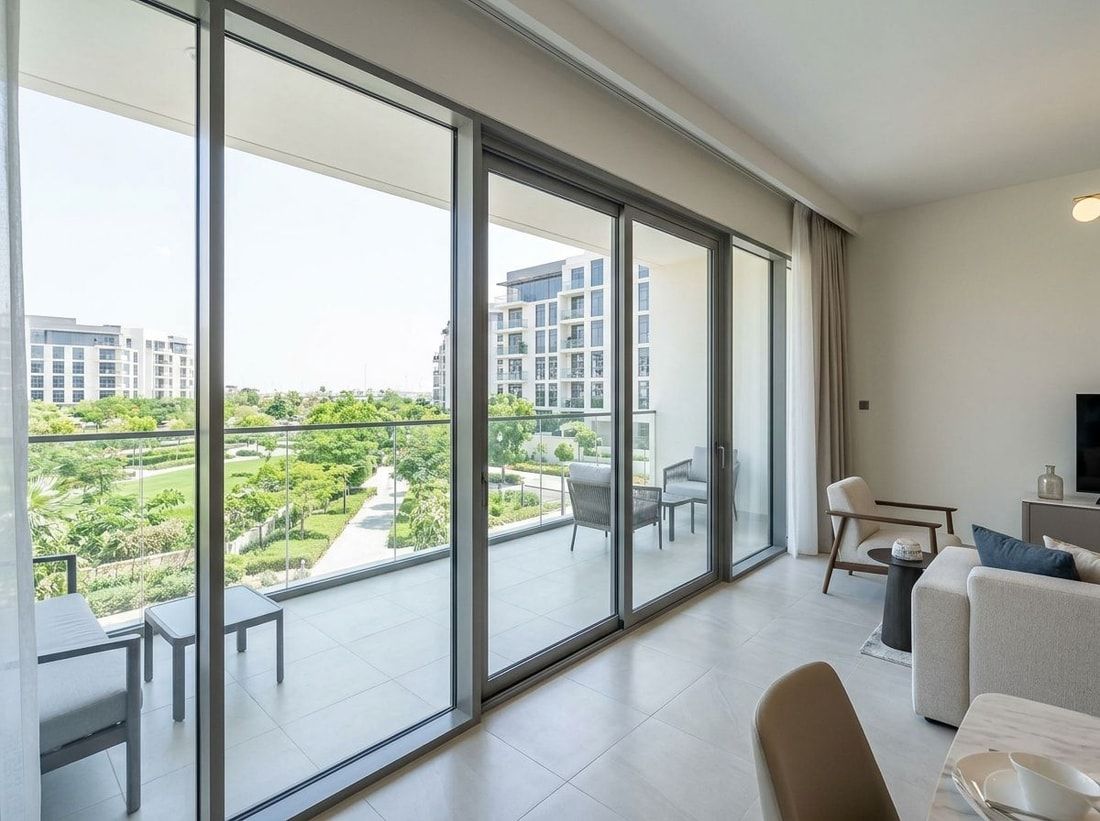 Jasny salon apartamentu z balkonem i widokiem na zieleń